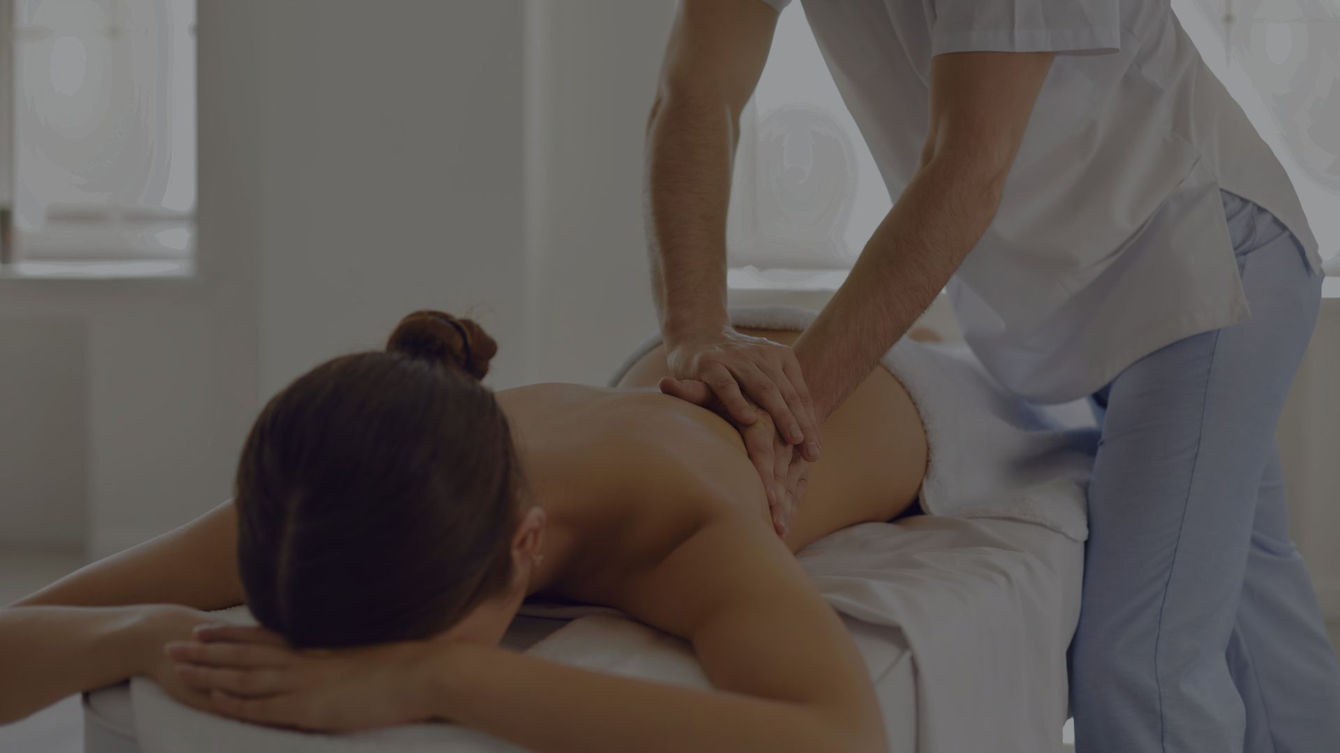Woman Lying on Massage Table Getting Medical Back Massage in Modern Physiotherapy Center
